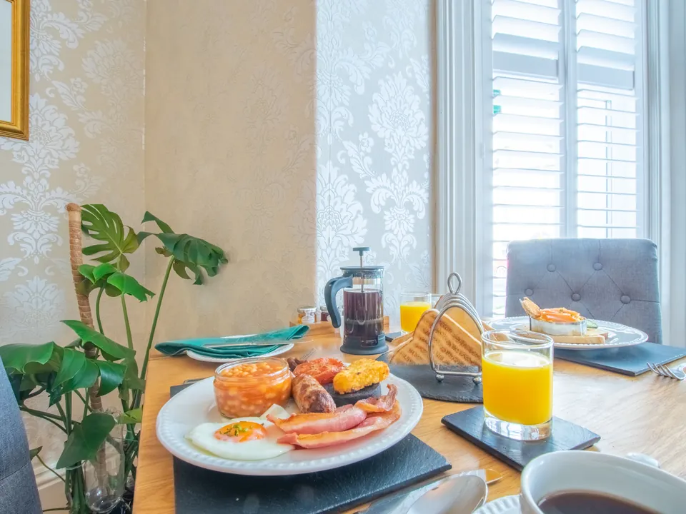 A full Welsh breakfast with bacon, sausage, beans and egg, with toast and orange juice