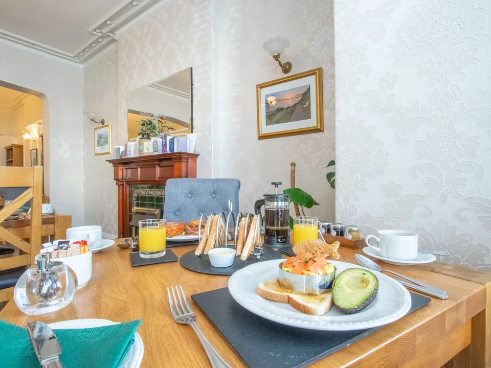 Scrambled egg on toast with smoked salmon and avocado, in the breakfast room