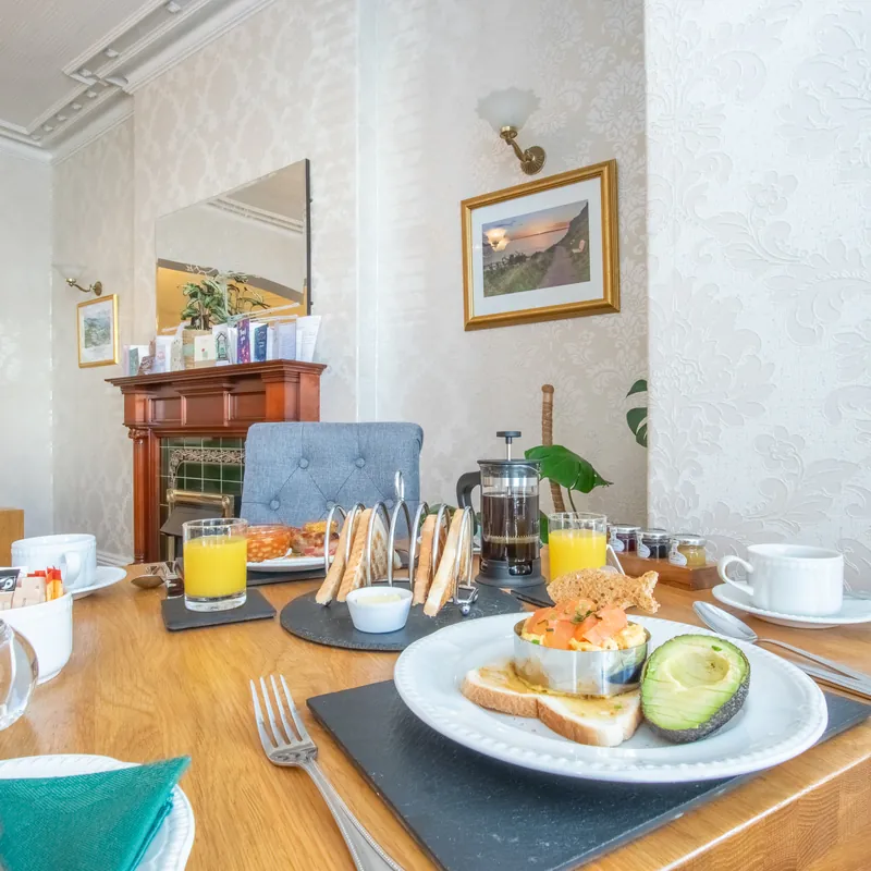 Scrambled egg on toast with smoked salmon and avocado, in the breakfast room