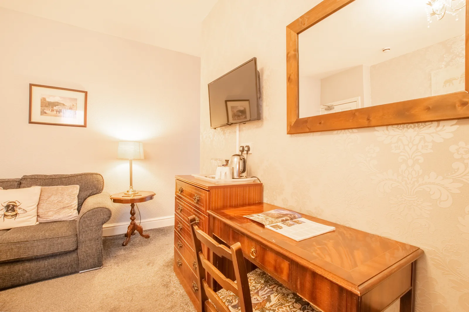 Beaumaris, Room 1: the sofa, a chest of drawers with the tea and coffee tray, a writing table and a wall-mounted TV
