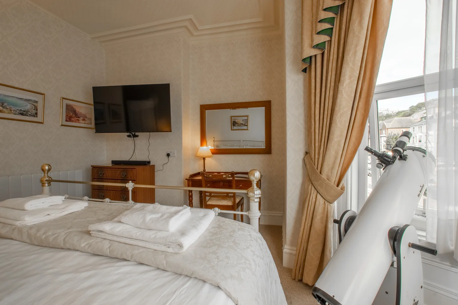 Adcote Suite, Room 3: the foot of the bed, the TV and dressing table, and the telescope looking out of the window