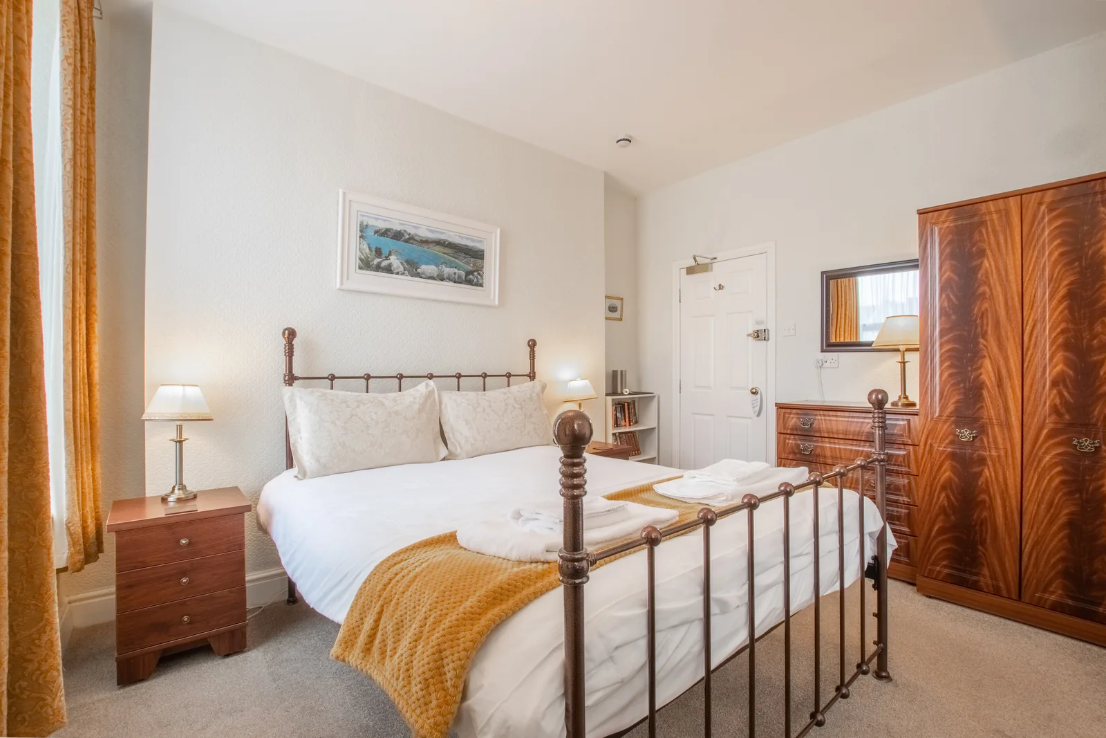 Conwy Studio, Room 6: the bed, a mahogany wardrobe and chest of drawers, and the door