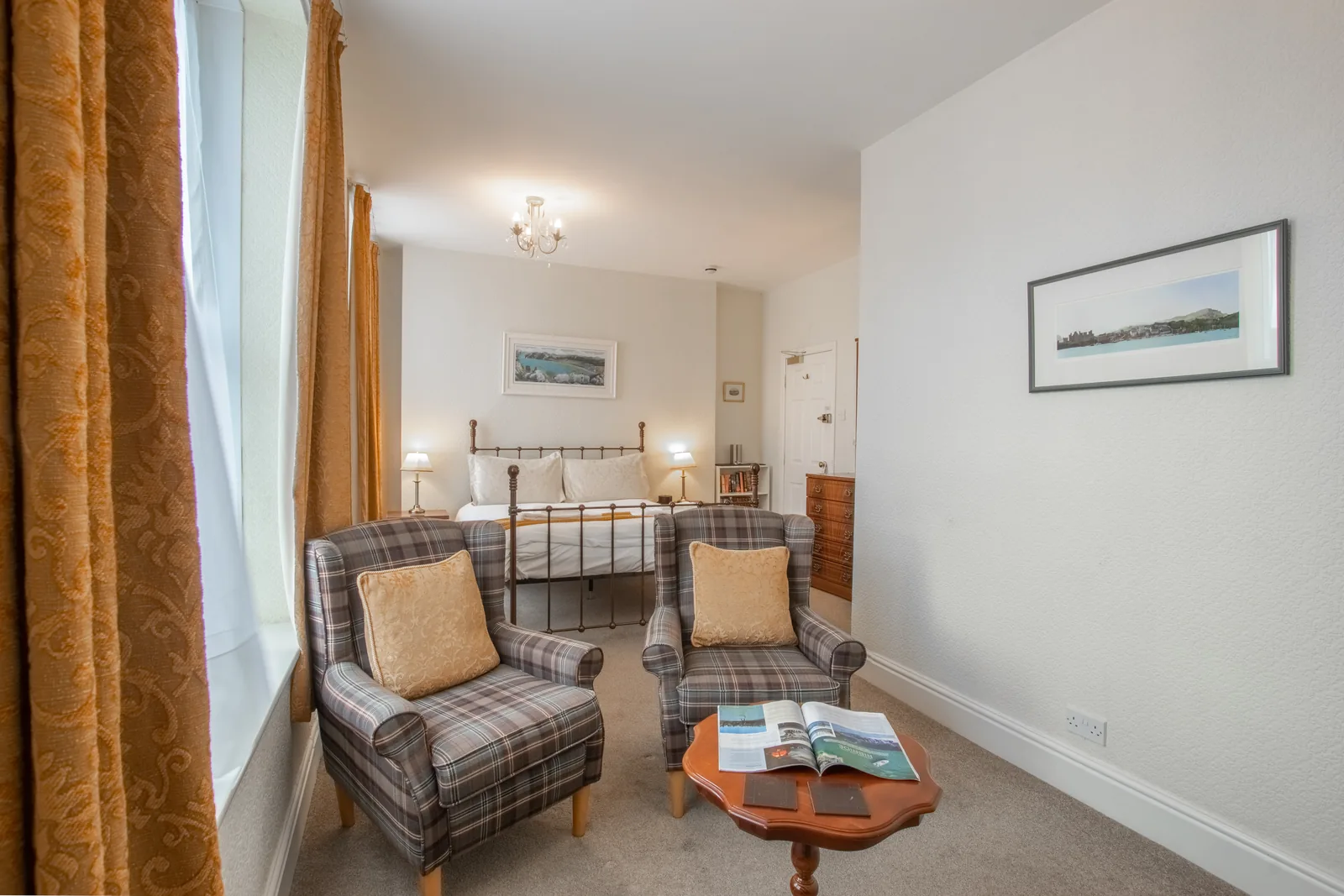 Conwy Studio, Room 6: the sitting area, with two tartan armchairs and a small table, and the bed behind